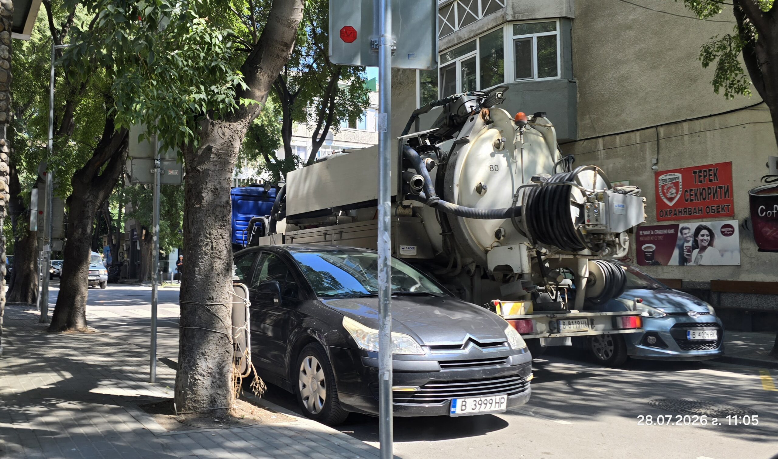 Син камион MAN с варненски номер B 8119 HA, спрял на тясната улица Радко Димитриев във Варна в непосредствена близост до контейнери за разделно събиране на боклук.