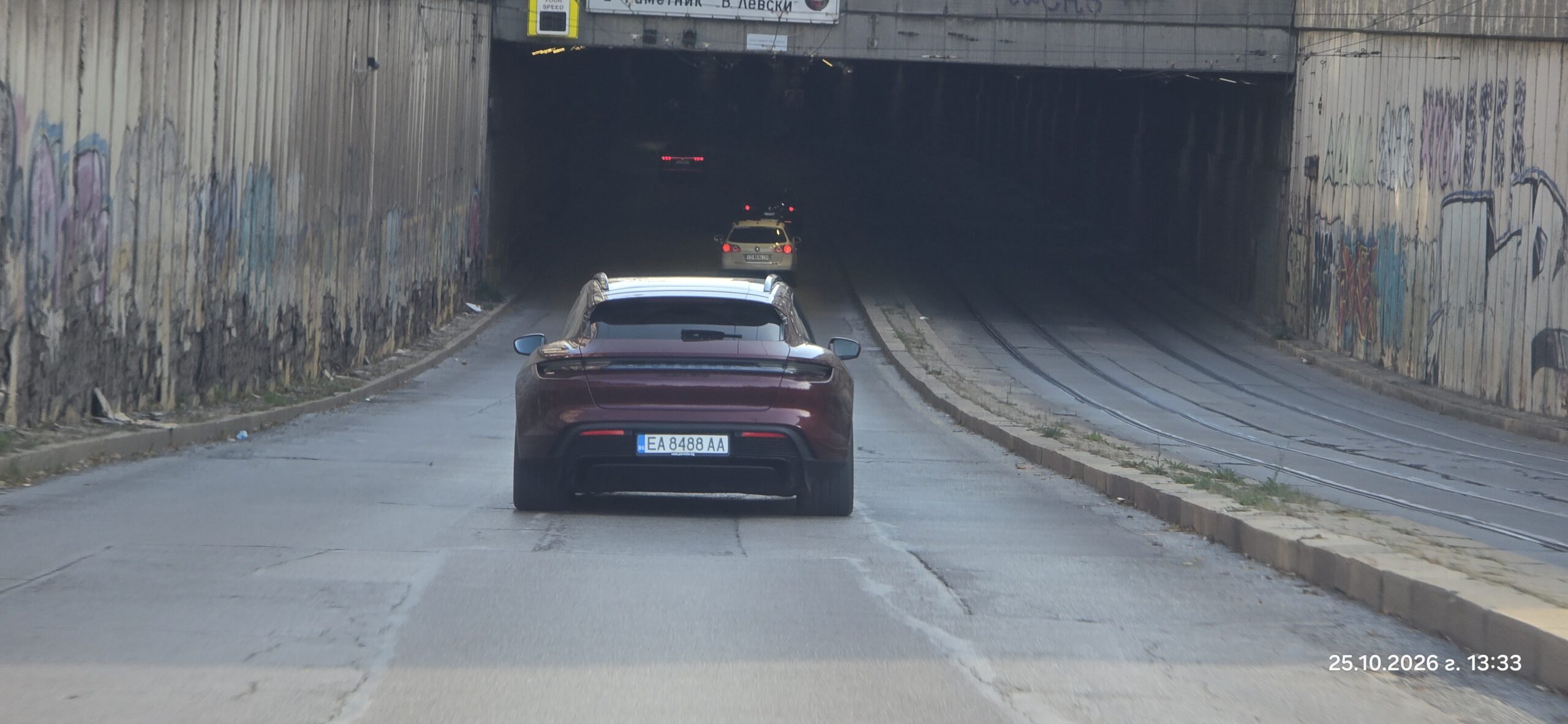 Задна част на виненочервено Porsche Taycan с регистрационен номер ЕА 8488 АА в тунел в София