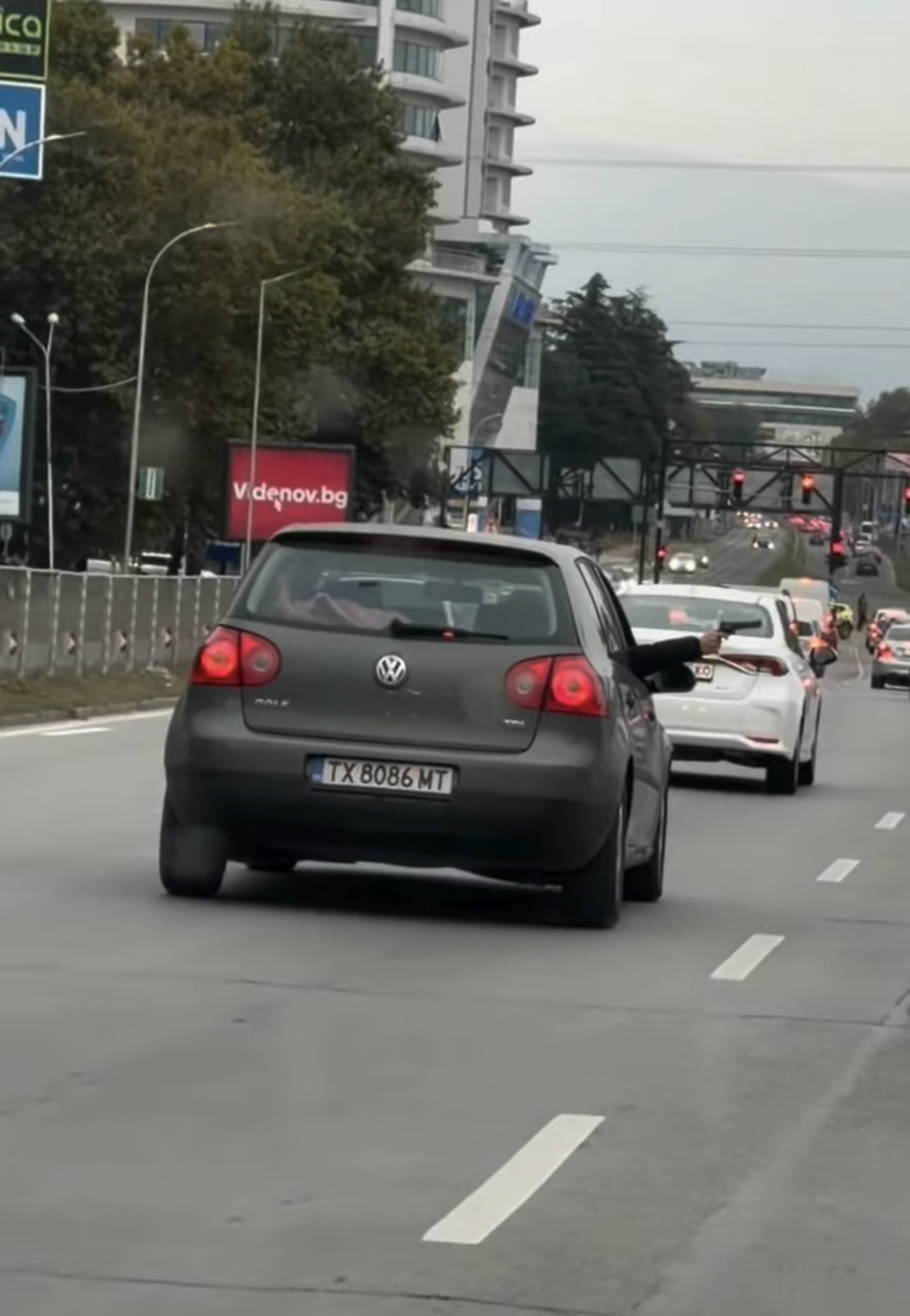 Сив лек автомобил Volkswagen Golf с добришка регистрация TX 8086 MT, движещ се по булевард във Варна, от чийто преден прозорец се подава ръка с пистолет.