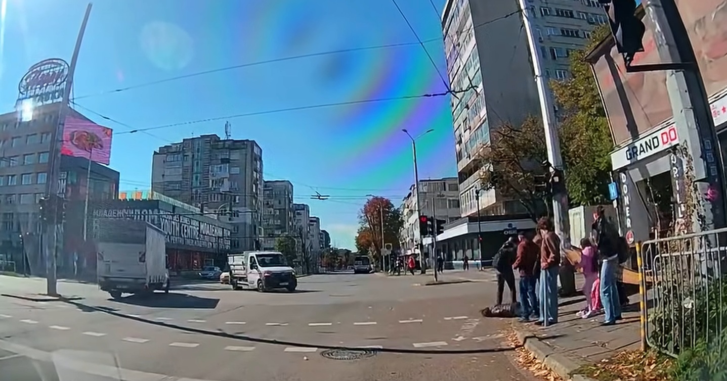Кадър от видеорегистратор на кръстовището до Червения площад във Варна, на който се вижда как пешеходци са помогнали на паднала на асфалта жена до знак за Младежки център.